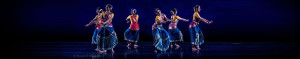 6 women dancing in a circle with colorful dresses